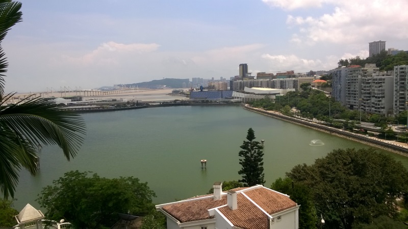 View from the hill over the reservoir, the ferry terminal on the left and the Eastern bridge to Taipa